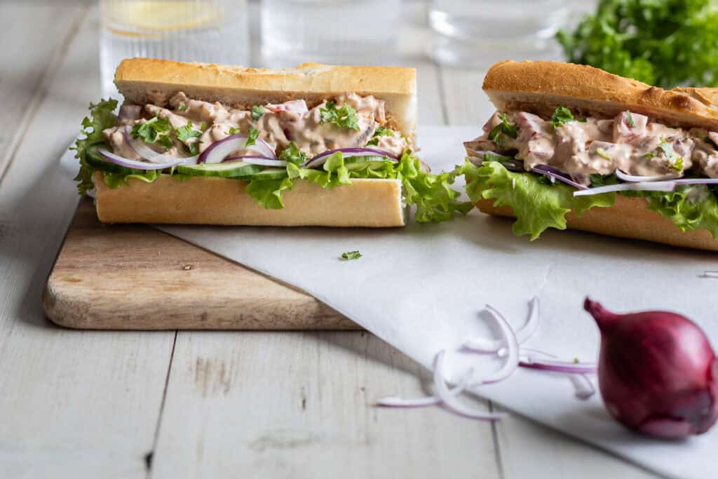 Laxmacka med färsk fiskröra, sallad och lök på baguette.