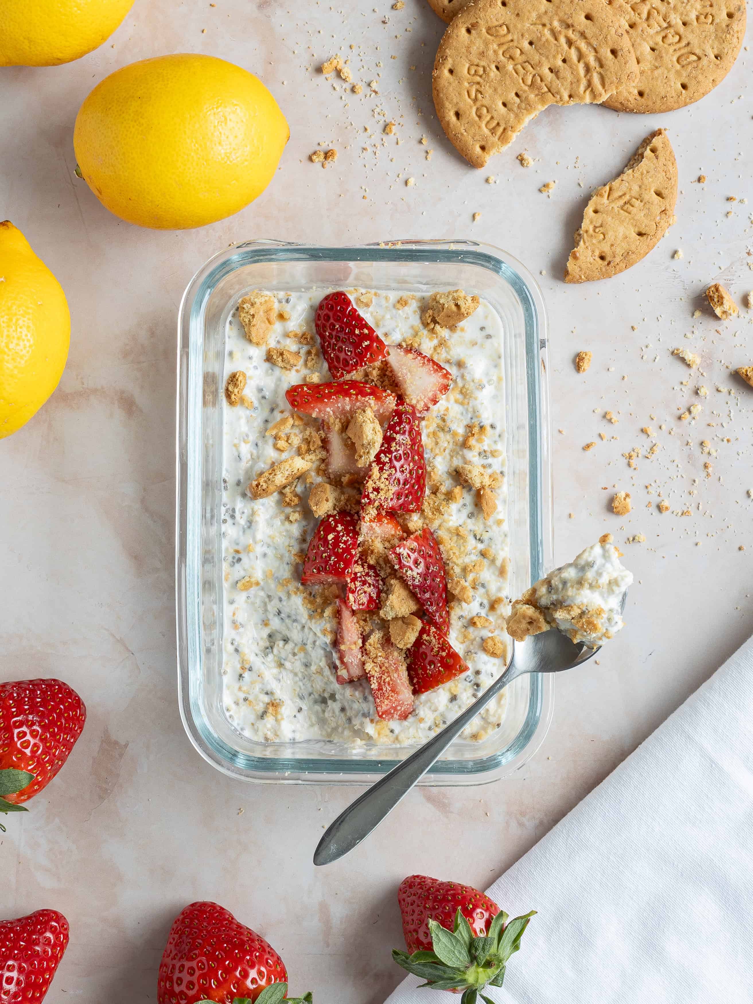 Lemon och jordgott dessert i glas med krossade kakor och färska jordgubbar.