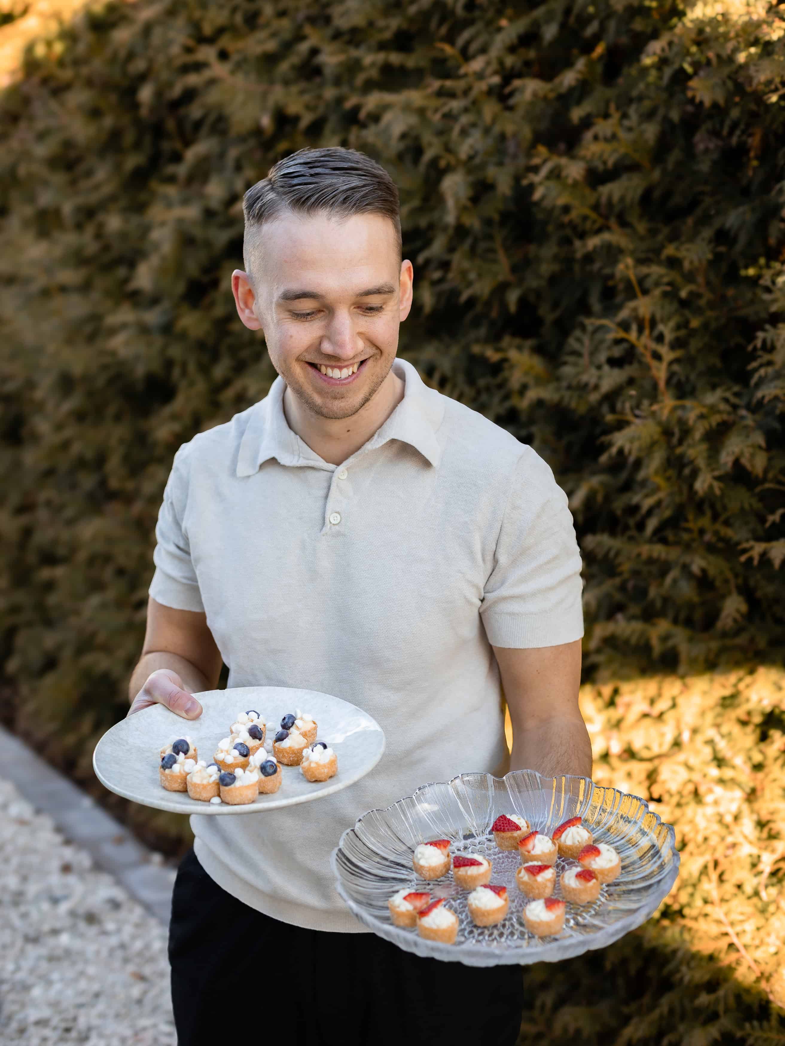 Glad man med bakverk i trädgården.