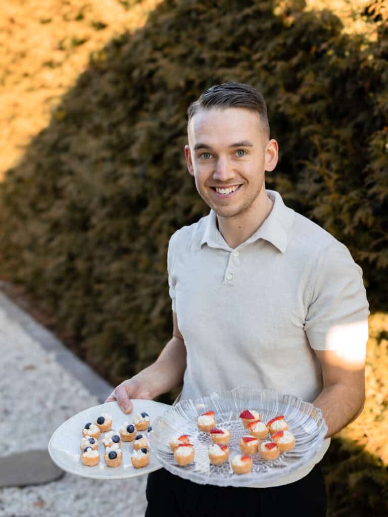 Mikaela Nordin håller ett fat med små bakverk utomhus.