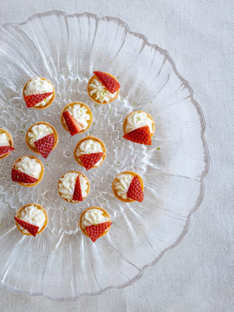 Jordgubbar fyllda med vaniljkräm på ett glasfat.