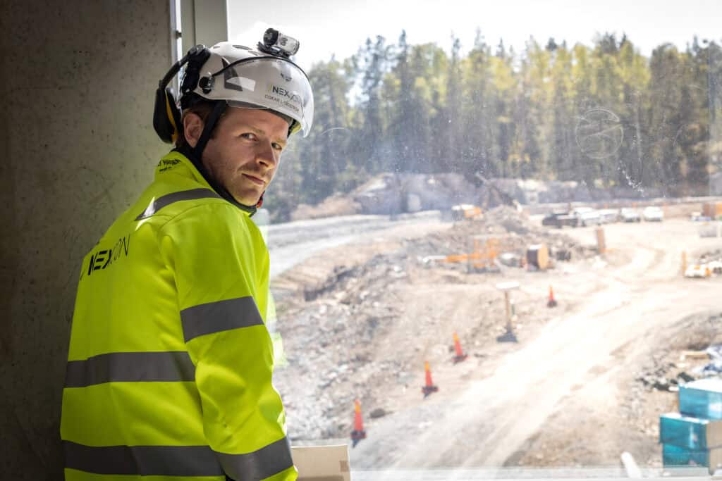 Byggarbetare i högsynk med skyddsutrustning på en byggarbetsplats i Uppsala.