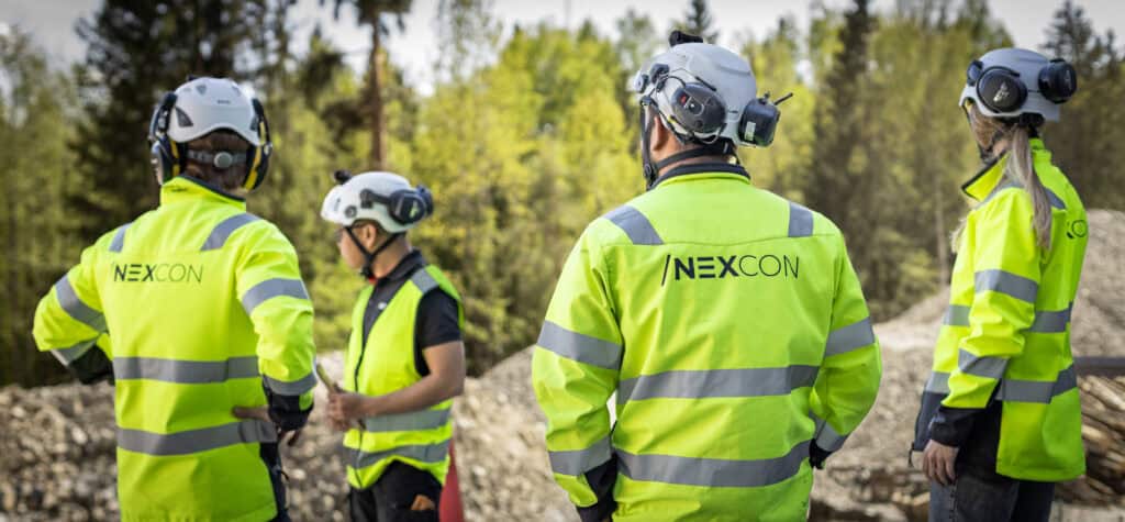 Grupp av NEXCON-anställda i höga synliga kläder i skog.