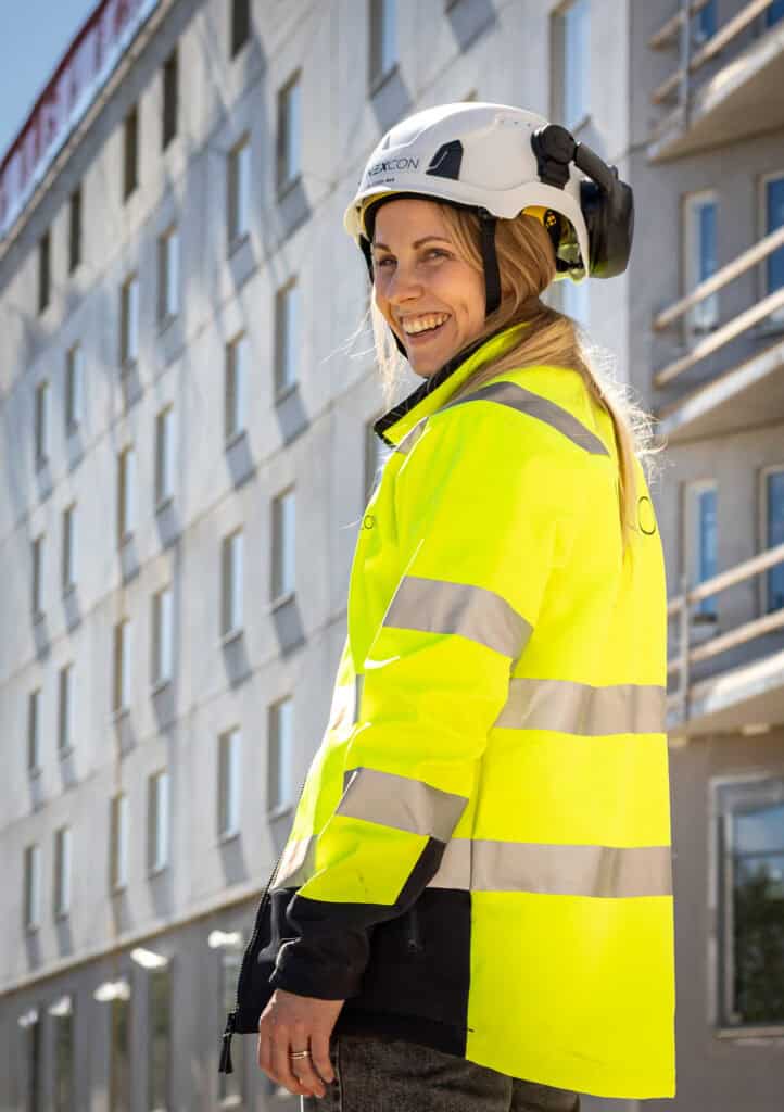 Byggarbetare i högsynkig väst och hjälm, utomhus i Uppsala.