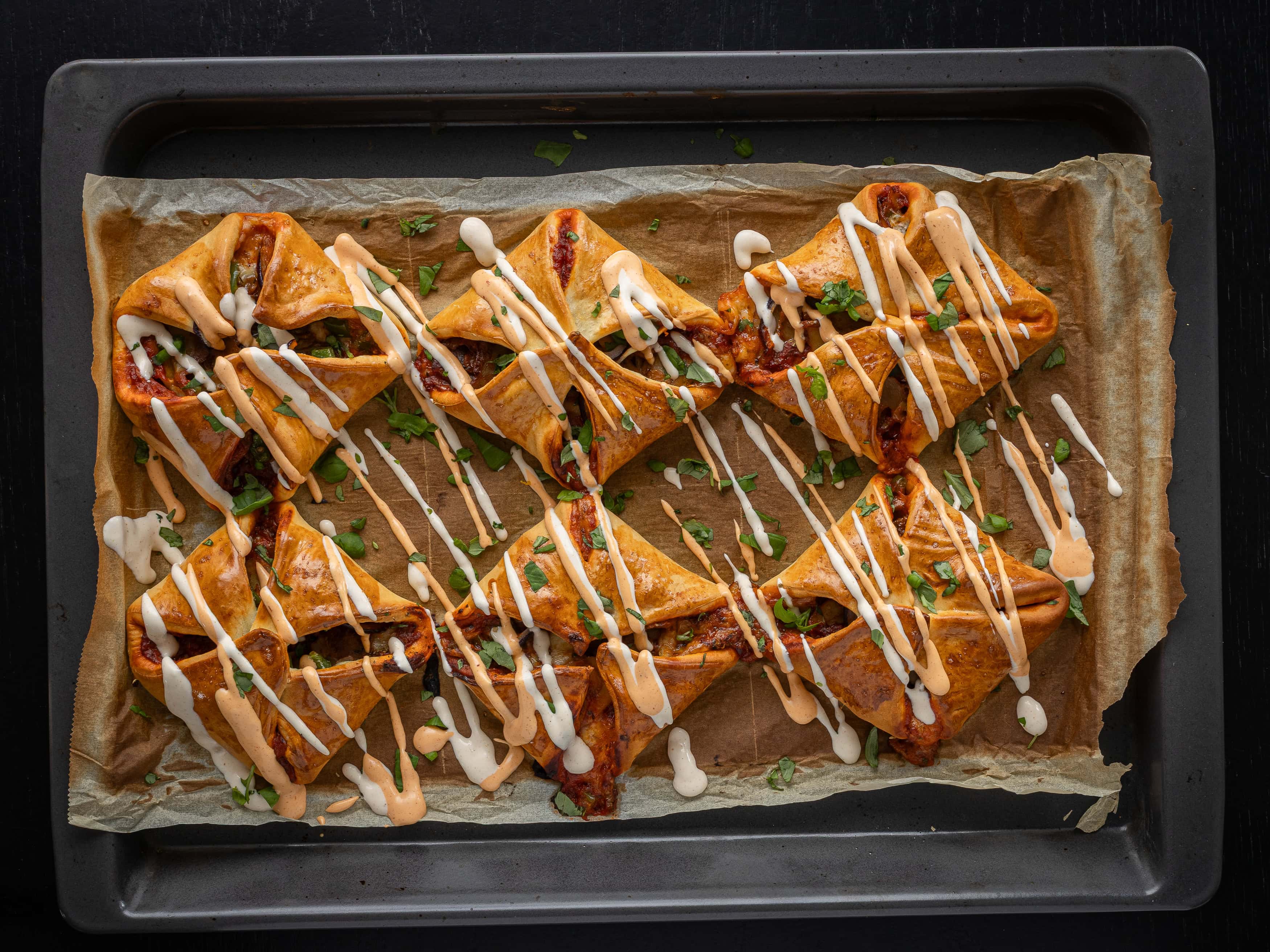 Vårrullar på bakplåt med krispig yta, toppade med sås och färska örter. Perfekt aptitretare eller sn.