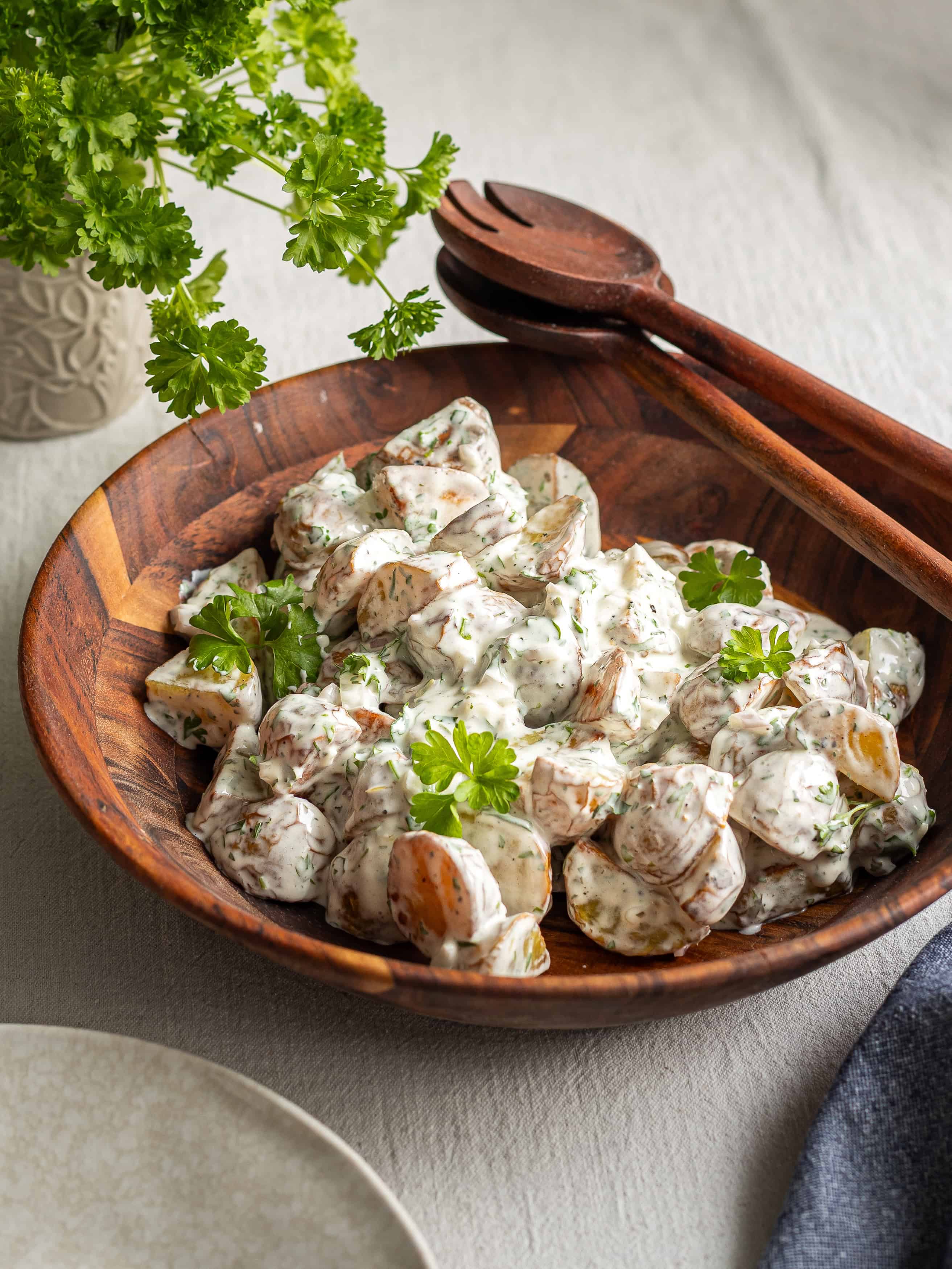 Potatissallad med gräslök i träskål, perfekt för sommarbuffé.